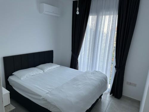 a bedroom with a bed and a large window at Sessiz tesisi in Kyrenia