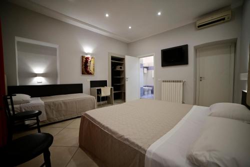 a hotel room with two beds and a television at Hotel Demo' in Milan