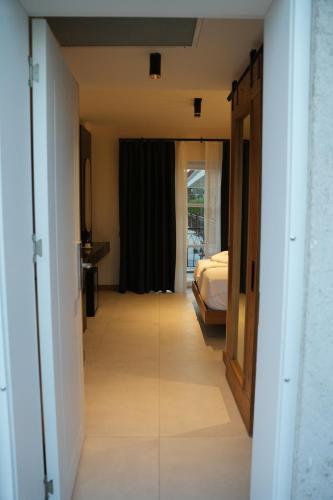 a hallway leading to a bedroom with a bed at Q Alaçatı Luxury Hotel in Cesme