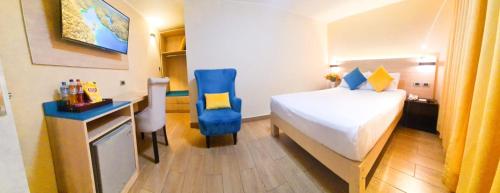 a hotel room with a bed and a desk with a desk at Acuario Hotel & Suite in Lima