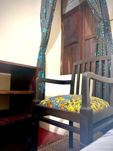 a wooden chair with a colorful blanket on it at Serene Abodes in Zanzibar City