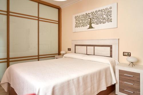 a white bedroom with a bed and a window at O Forte in Cangas de Morrazo