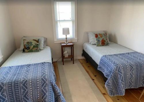 ein Schlafzimmer mit zwei Betten und einem Fenster in der Unterkunft Charming Cottage with Amazing Views in Truro