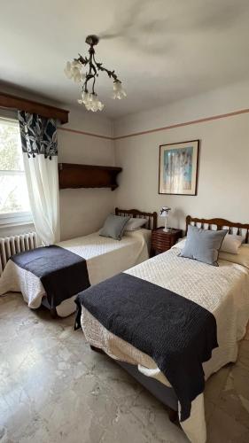 une chambre avec deux lits et un lustre dans l'établissement Maison typique de provence, à Saint-Rémy-de-Provence