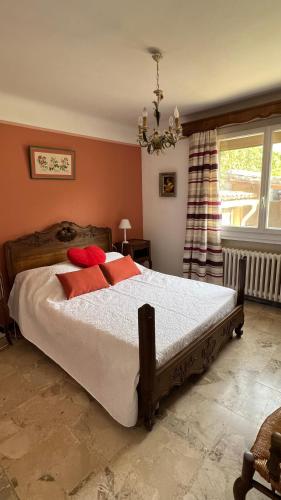 une chambre avec un grand lit avec des oreillers rouges dans l'établissement Maison typique de provence, à Saint-Rémy-de-Provence