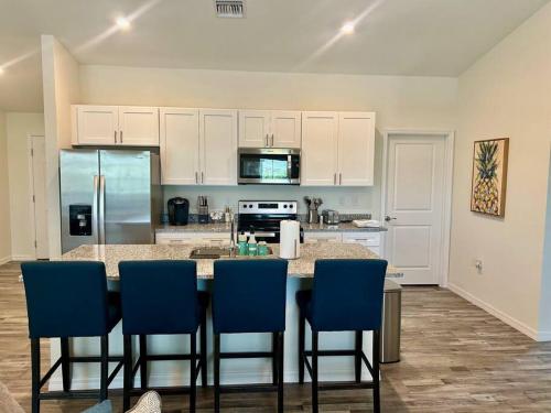 a kitchen with a table with chairs and a refrigerator at New With heated Pool and Pier! Ideal for 2 Families! in Cape Coral