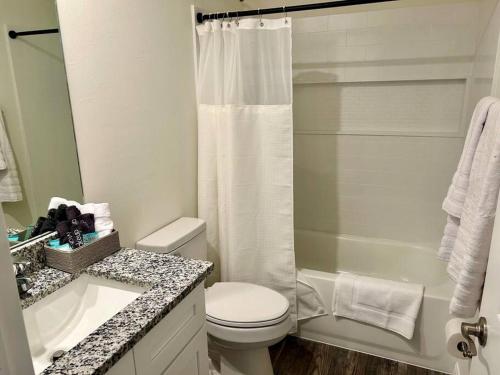 a white bathroom with a toilet and a shower at New With heated Pool and Pier! Ideal for 2 Families! in Cape Coral