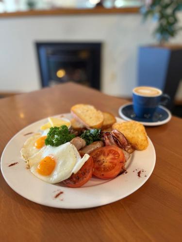 a plate of food with eggs and tomatoes on a table at Comfort Hotel Flames Whangarei in Whangarei
