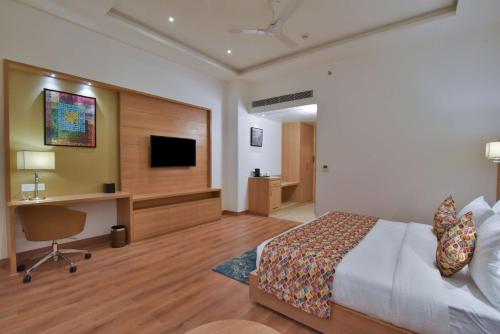 a bedroom with a bed and a desk and a television at Best Western Summerlea in Jalandhar