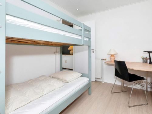 a bedroom with a bunk bed and a desk at 4 star holiday home in Blokhus-By Traum in Blokhus