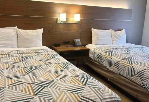 two beds sitting next to each other in a hotel room at Motel 6 Phoenix, AZ Midtown in Phoenix