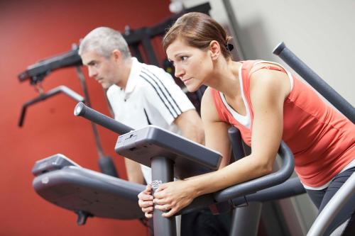 a man and woman on a treadmill in a gym at bigBOX ALLGAEU Hotel in Kempten
