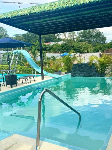 a pool with a slide in a resort at Villa Tungara in Bejuco