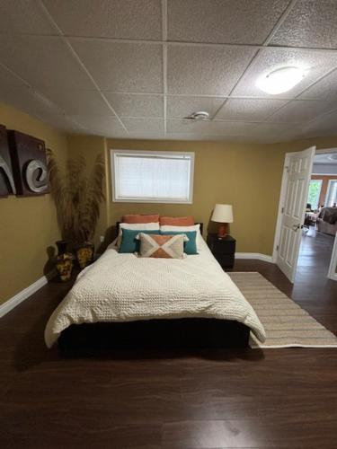 a bedroom with a large bed with blue and orange pillows at Suite Sunrise in Maclennan Township