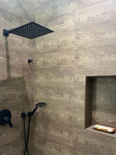 a shower with a shower head and a mirror at Cove Chalet 1شاليه كوڤ in Al Ahsa