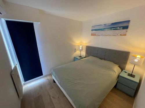 une petite chambre avec un lit et une fenêtre dans l'établissement Family apartment - Fully equipped, Close to sandy beaches & restaurants, Pool, Balcony, Garage, à Antibes