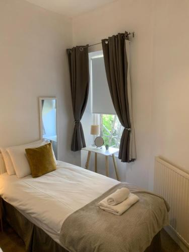 a bed with two towels on it in a bedroom at Stockbridge Two Bedroom Apartment in Edinburgh