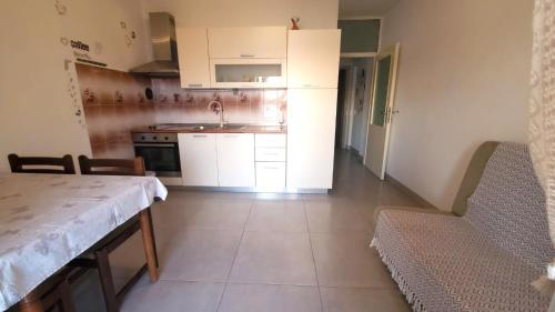 a kitchen with white cabinets and a table and chairs at Relax A 3 in Zaboric