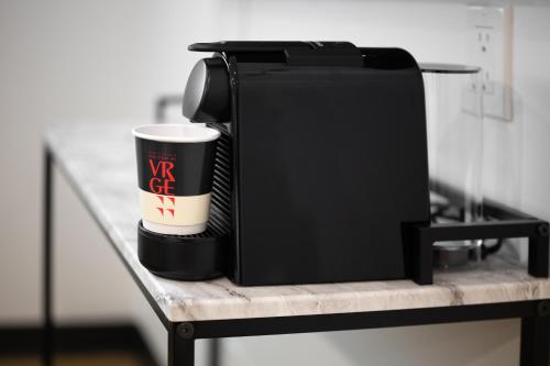 a cup of coffee sitting on a shelf with a coffee cup at VRGE Revelstoke in Revelstoke