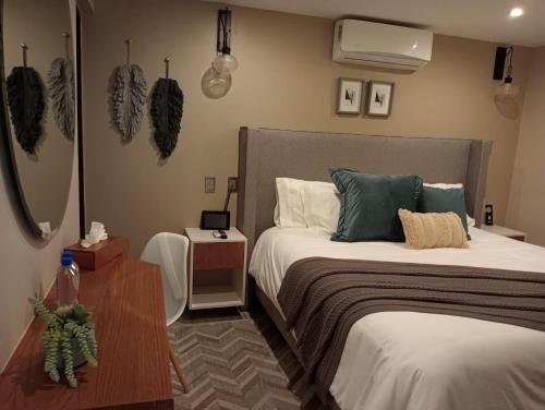 a bedroom with two beds and a table with a night stand at Hotel Boutique Corazón Mexicano in Guanajuato