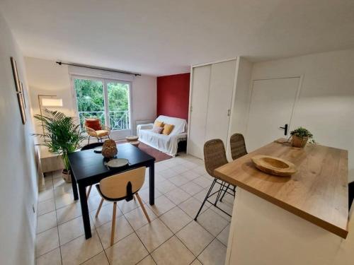 une cuisine et un salon avec une table et des chaises dans l'établissement Charmant 2 pièces à Longjumeau, à Longjumeau