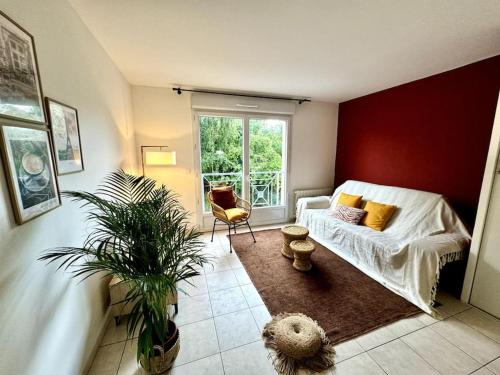 - un salon avec un canapé blanc et une fenêtre dans l'établissement Charmant 2 pièces à Longjumeau, à Longjumeau