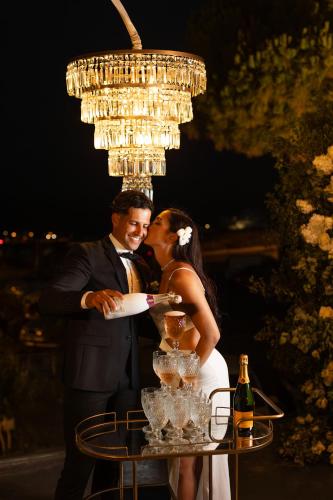 a bride and groom kissing under a chandelier at Ayama Hideaway Private Villa in Fira