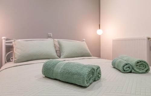a bed with two green towels on top of it at My Nafpaktos Resort in Nafpaktos