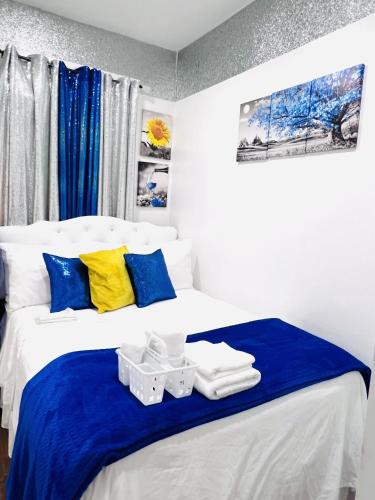 a bedroom with a bed with blue and yellow pillows at Imperial Stay BNB in Brooklyn