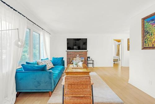a living room with a blue couch and a table at Walk to Lake - Old Town Retreat in Niagara on the Lake