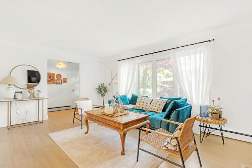 un salon avec un canapé bleu et une table dans l'établissement Walk to Lake - Old Town Retreat, à Niagara on the Lake