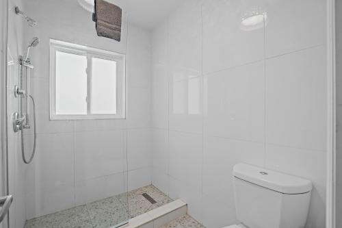 a white bathroom with a shower and a toilet at The Pearl Cabana Club in St Pete Beach