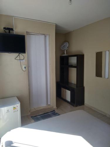 Pousada Nhá Chica في ساو ثومي داس ليتراس: غرفة بسرير وباب مع تلفزيون