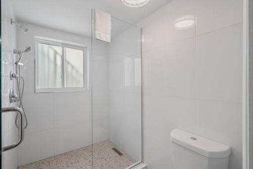 a white bathroom with a shower and a toilet at The Pearl Cabana Club in St Pete Beach