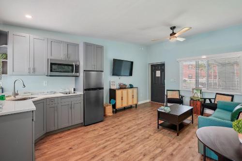 a kitchen and living room with white cabinets and a couch at The Pearl Cabana Club in St Pete Beach