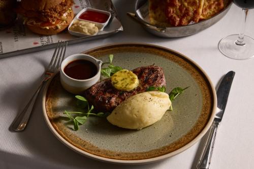 a plate of food with meat and sauce on a table at Stamford Plaza Melbourne in Melbourne