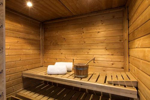 a wooden sauna with two towels and a bucket at Holiday Inn Eindhoven Centre by IHG in Eindhoven