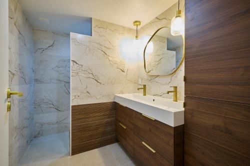 une salle de bain avec un lavabo blanc et un miroir dans l'établissement Maison familiale Piscine & Spa, à Orsay