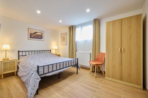 une chambre avec un lit, une chaise et une fenêtre dans l'établissement Maison familiale Piscine & Spa, à Orsay