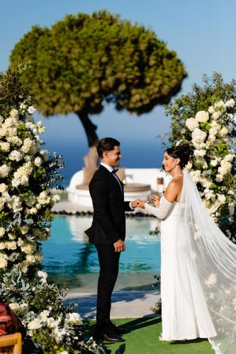 a bride and groom standing next to each other at San Marino Suites by Calm Collection in Fira