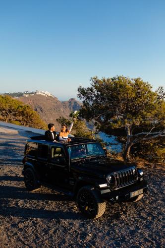 two people sitting in the back of a black jeep at San Marino Suites by Calm Collection in Fira