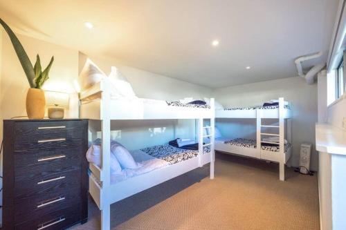two white bunk beds in a room with a dresser at PAH VIEW HOUSE - Coast and Country in Onetangi
