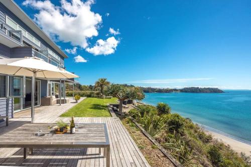 a house with a picnic table and the ocean at PAH VIEW HOUSE - Coast and Country in Onetangi