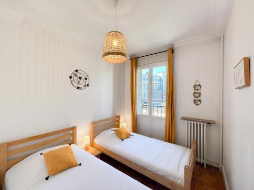 une chambre avec deux lits et une fenêtre dans l'établissement Le Chambellan, à Orléans