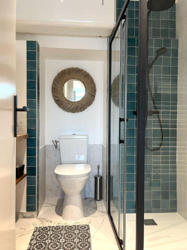 une salle de bain avec toilettes et douche en verre dans l'établissement Nomad Stay Biarritz, à Biarritz