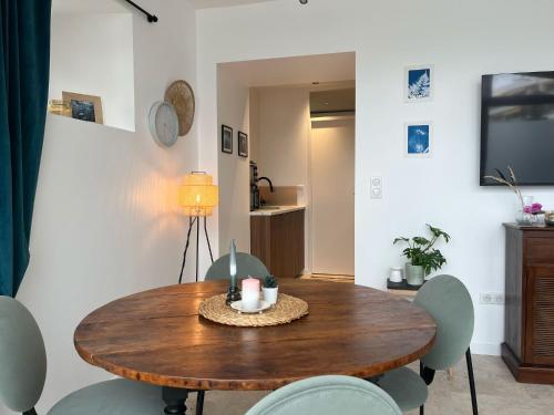une salle à manger avec une table et des chaises en bois dans l'établissement Nomad Stay Biarritz, à Biarritz