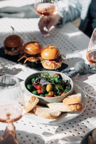a table with a bowl of salad and a plate of food at Rydges Newcastle in Newcastle