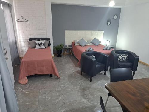a bedroom with two beds and a table and chairs at Monoambiente Eldorado I in Eldorado