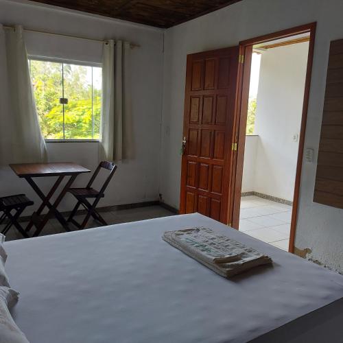 a bedroom with a bed and a table and a window at Rancho das Montanhas in Muniz Freire