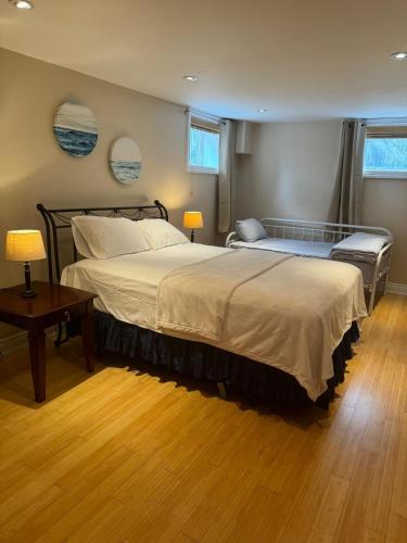a bedroom with a bed and a table and two windows at Luxury Apartment Living in Mississauga